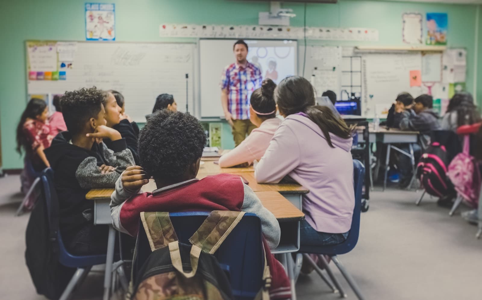 Students learning together around classroom tables